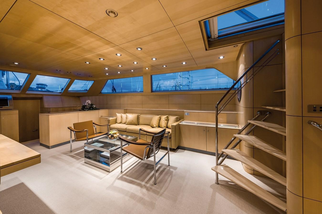a room with a couch and a table and a staircase aboard SPIIP Yacht for Sale