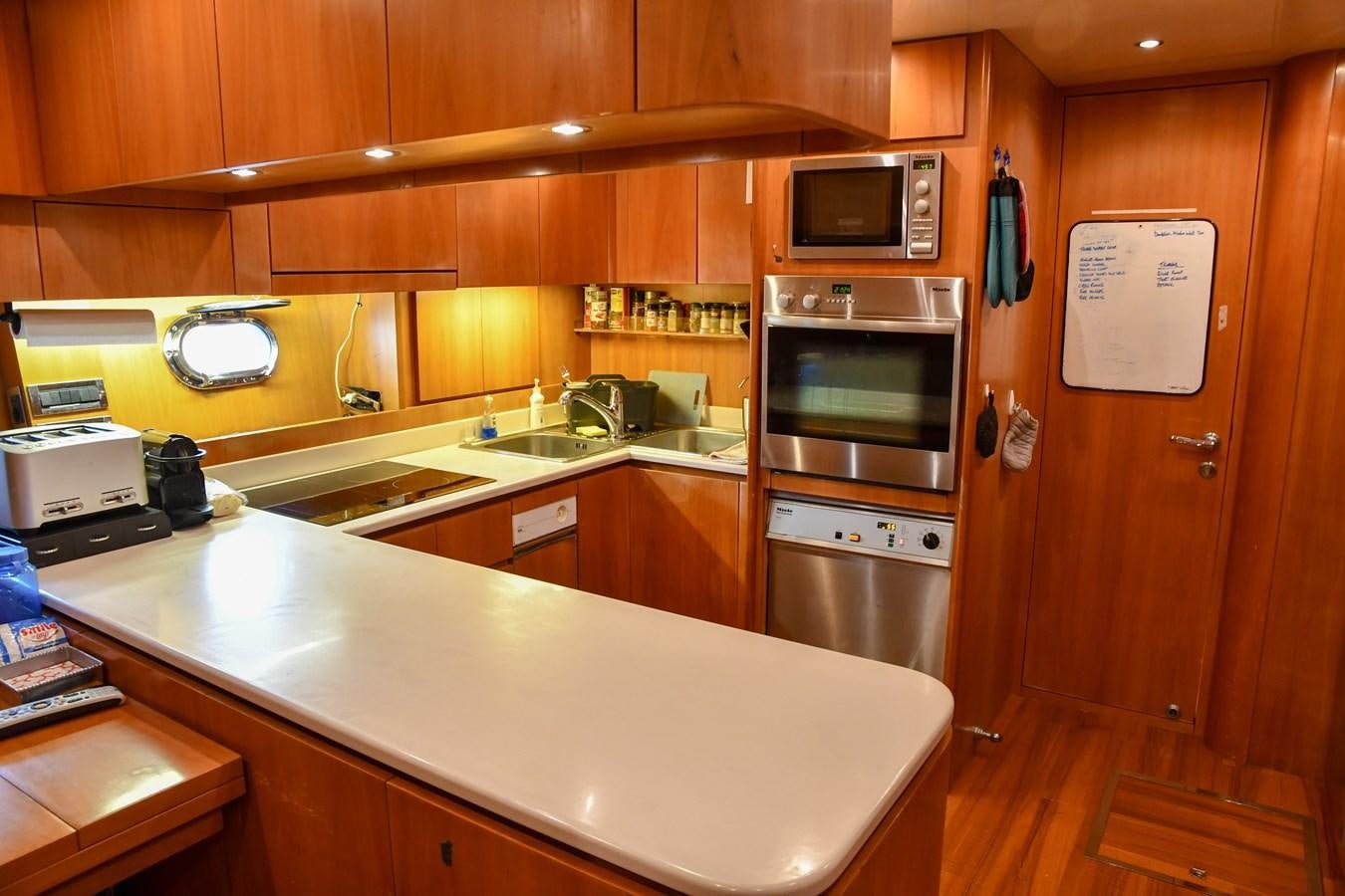 a kitchen with wooden cabinets aboard EYE PLAY Yacht for Sale