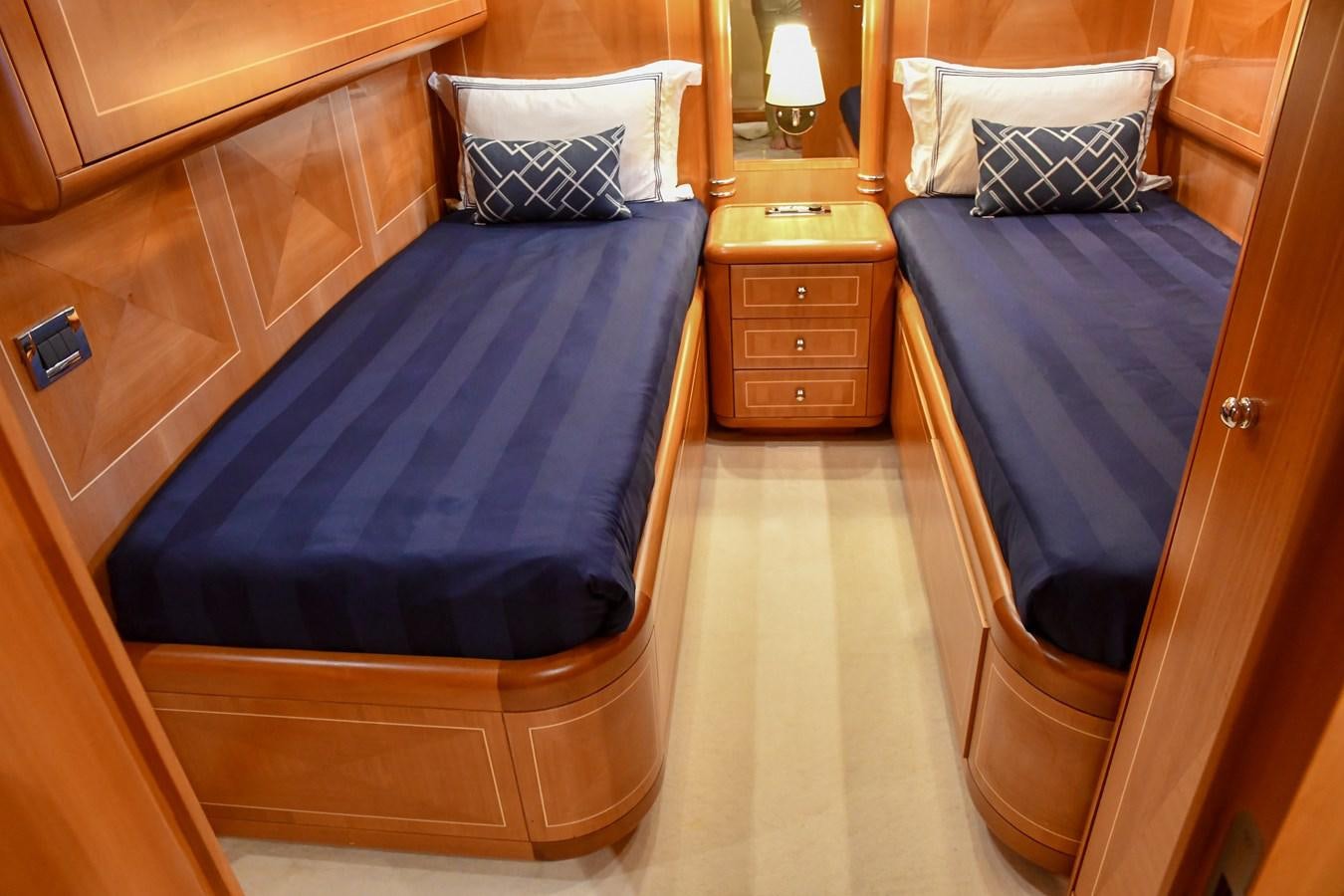 a bedroom with a bed and a dresser aboard EYE PLAY Yacht for Sale