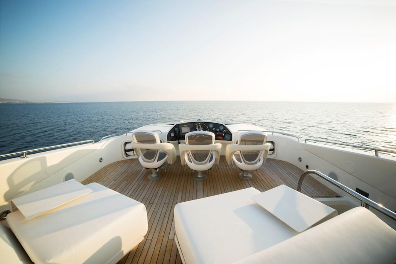 a table with chairs on it next to a body of water aboard BLADE 6 Yacht for Sale