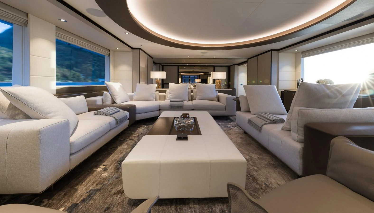 a living room with a large white couch and a large white table aboard LAURENTIA Yacht for Charter