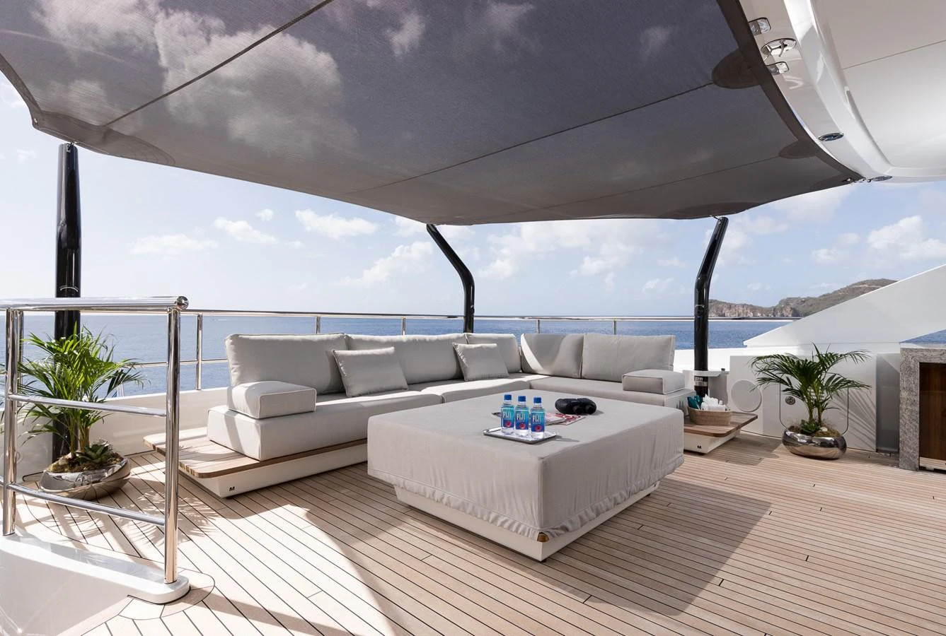 a living room with a large white sofa and a large window aboard LAURENTIA Yacht for Charter