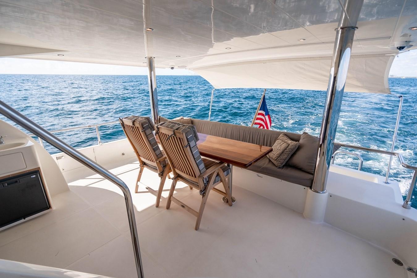 a deck with chairs and a flag on it aboard Miss Penny Yacht for Sale