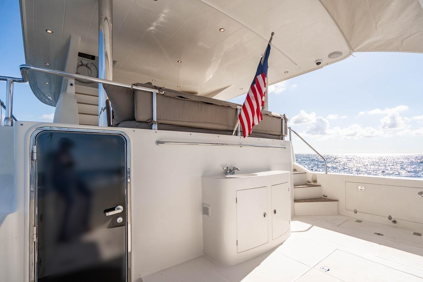 a boat with a flag on the deck aboard Miss Penny Yacht for Sale