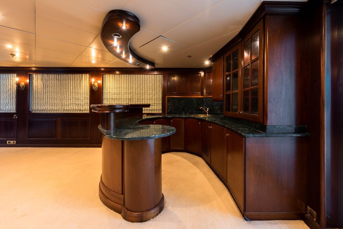 a room with a large bar and a large glass table aboard BIG ARON Yacht for Sale
