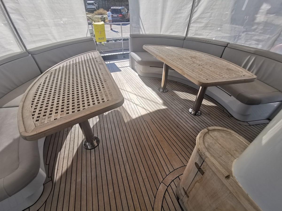 a wood table and chairs on a deck aboard ALBINA Yacht for Sale
