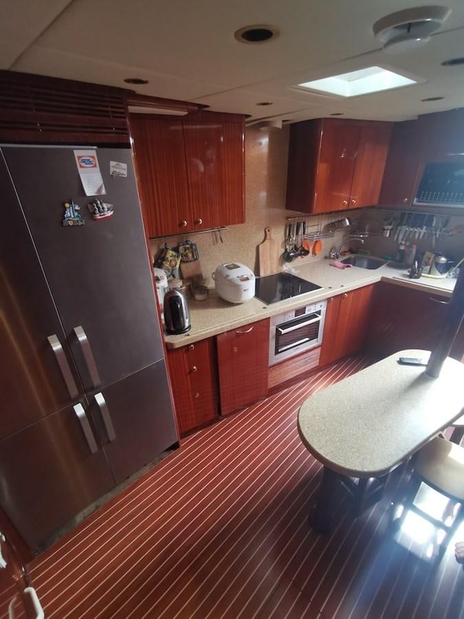 a kitchen with a fridge and a table aboard ALBINA Yacht for Sale