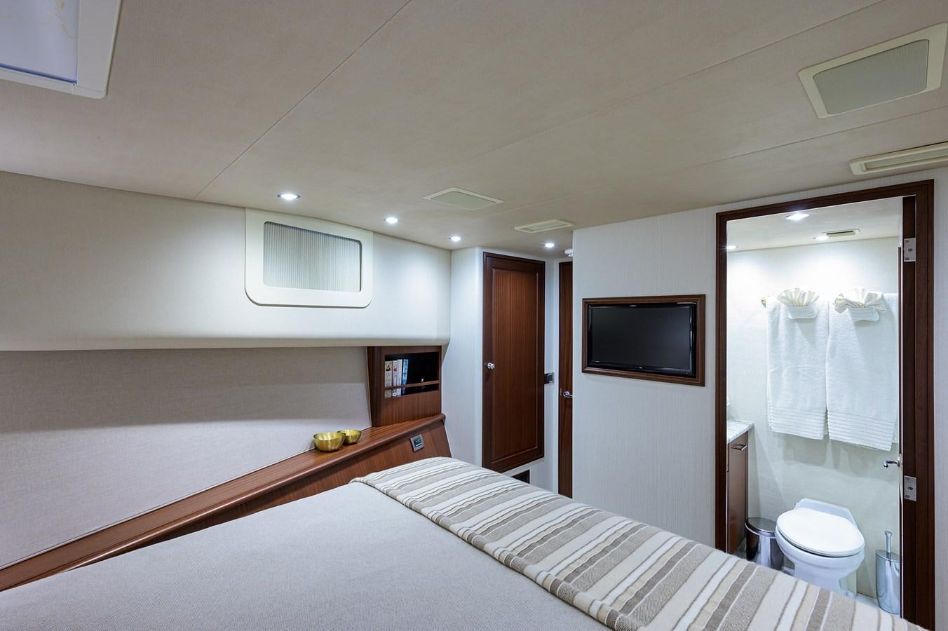 a bedroom with a bed and a television aboard ROBINSON CRUSOE Yacht for Sale