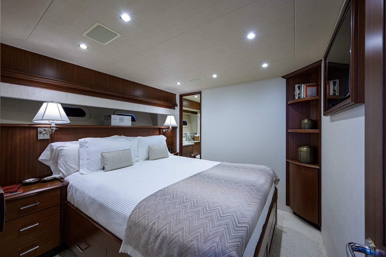 a bedroom with a bed and a bookcase aboard ROBINSON CRUSOE Yacht for Sale