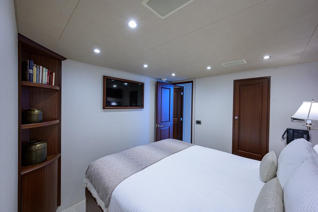a bedroom with a bed and a television on the wall aboard ROBINSON CRUSOE Yacht for Sale