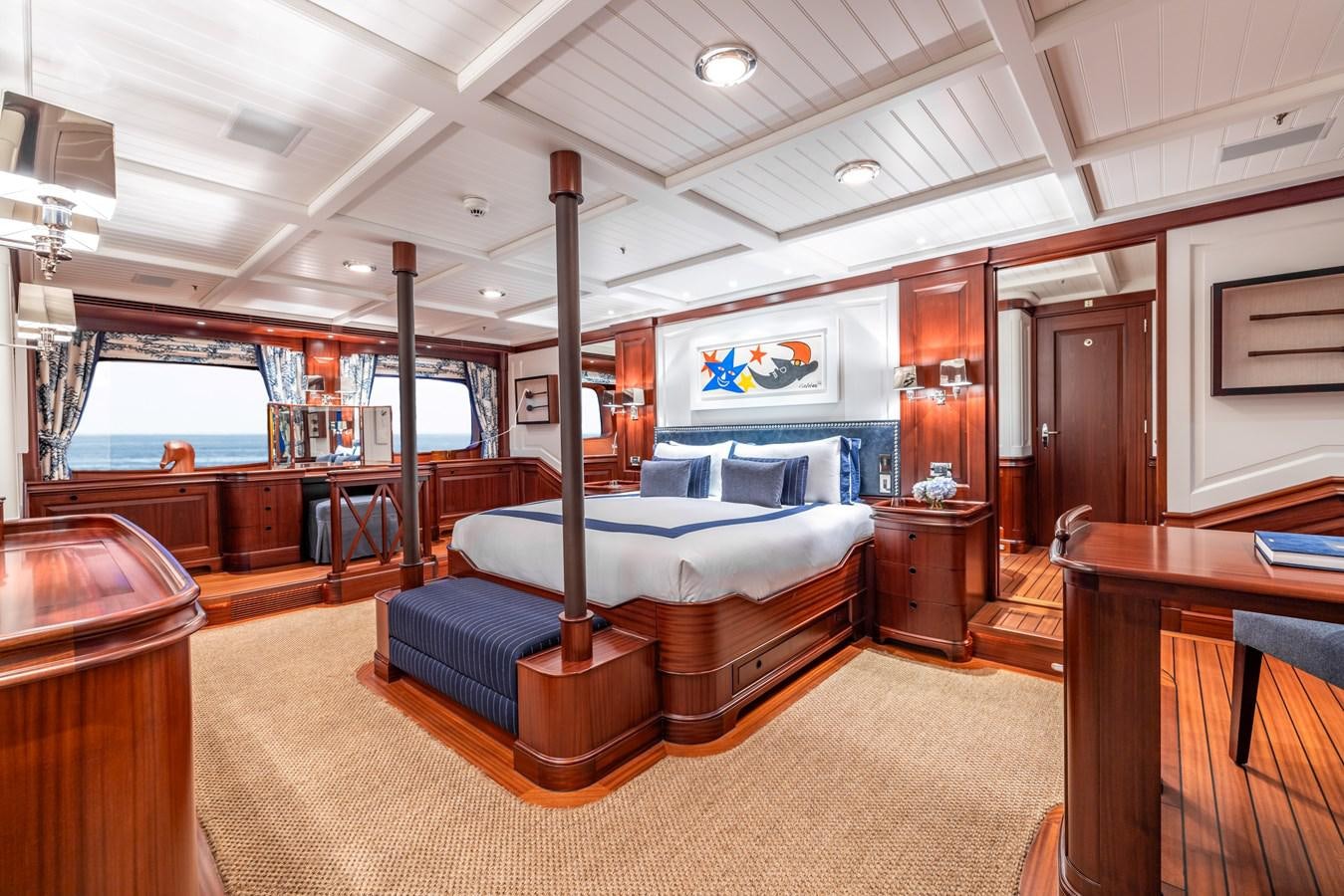 a bedroom with a bed and desk aboard AWATEA Yacht for Sale