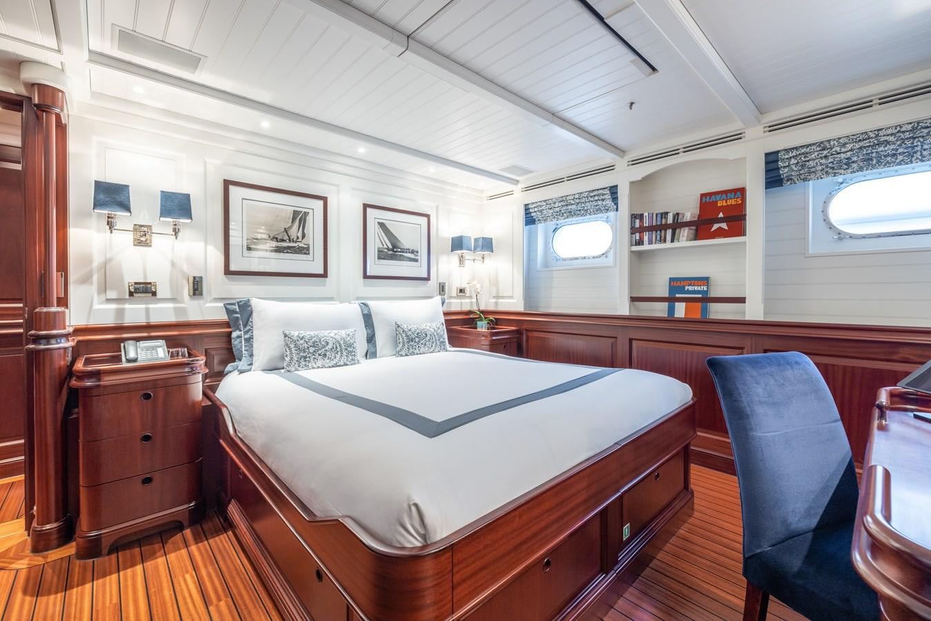 a bedroom with a bed and a desk aboard AWATEA Yacht for Sale