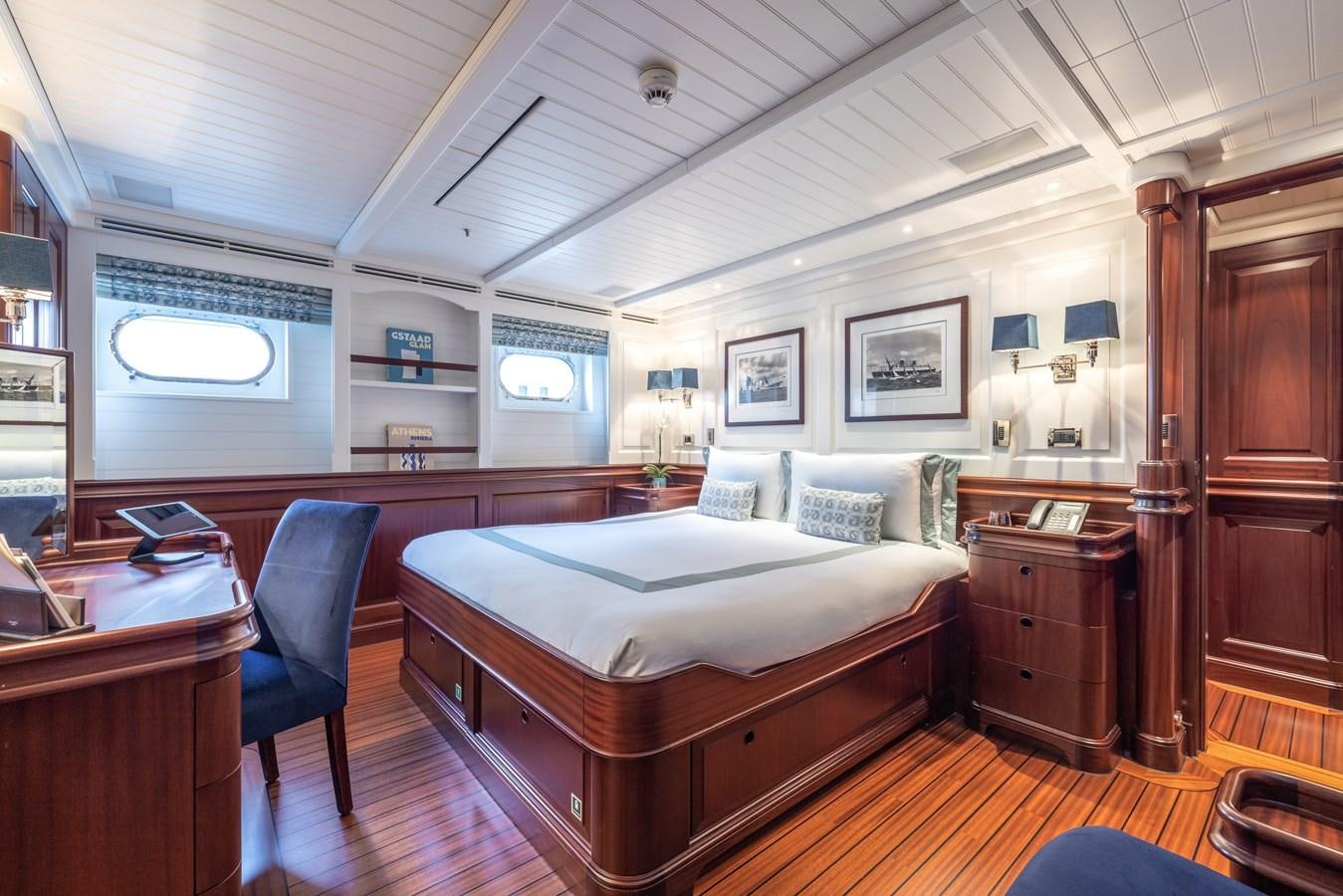 a bedroom with a bed and desk aboard AWATEA Yacht for Sale