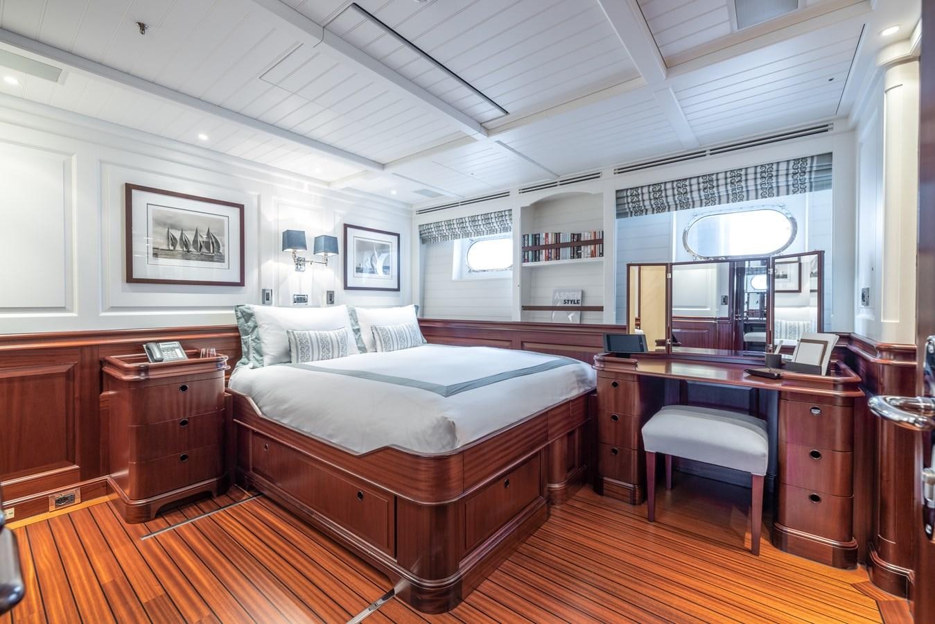 a bedroom with a bed and desk aboard AWATEA Yacht for Sale
