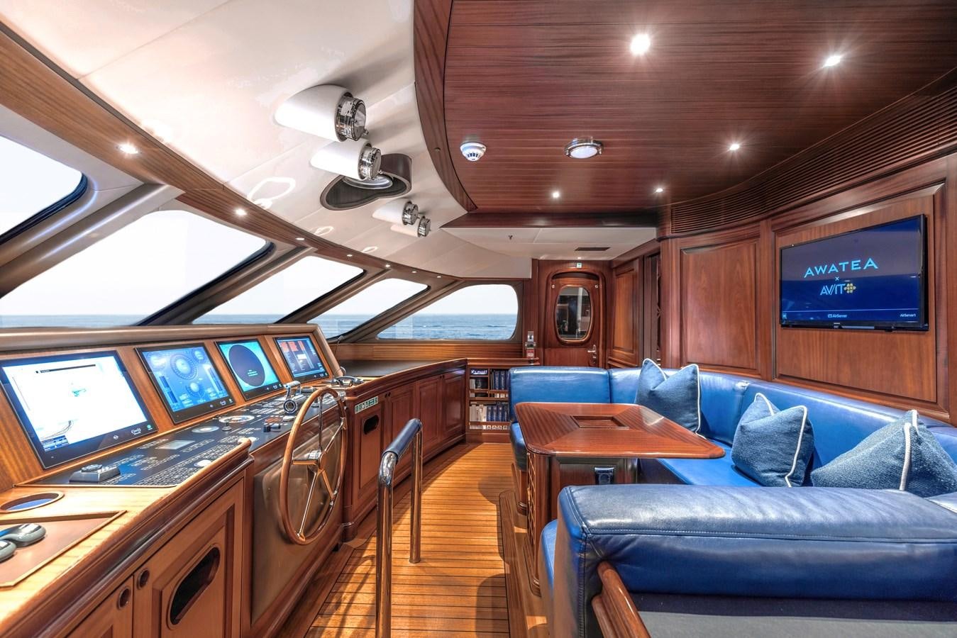 inside of a vehicle with a large screen and a table with chairs aboard AWATEA Yacht for Sale