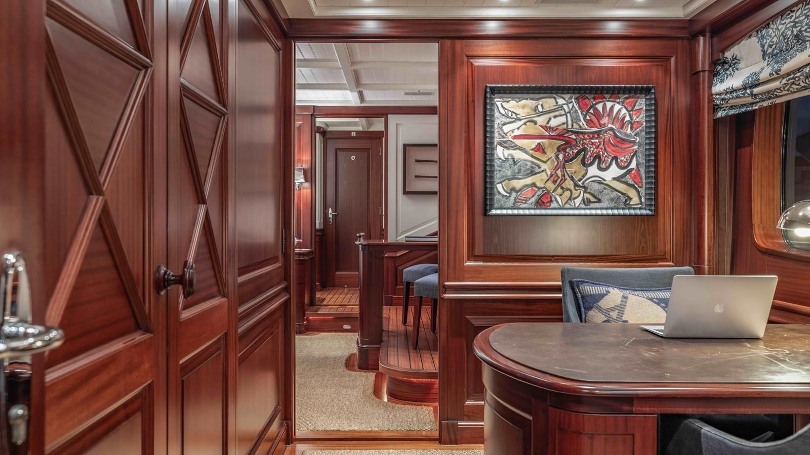 a room with a table and a laptop on a table aboard AWATEA Yacht for Sale