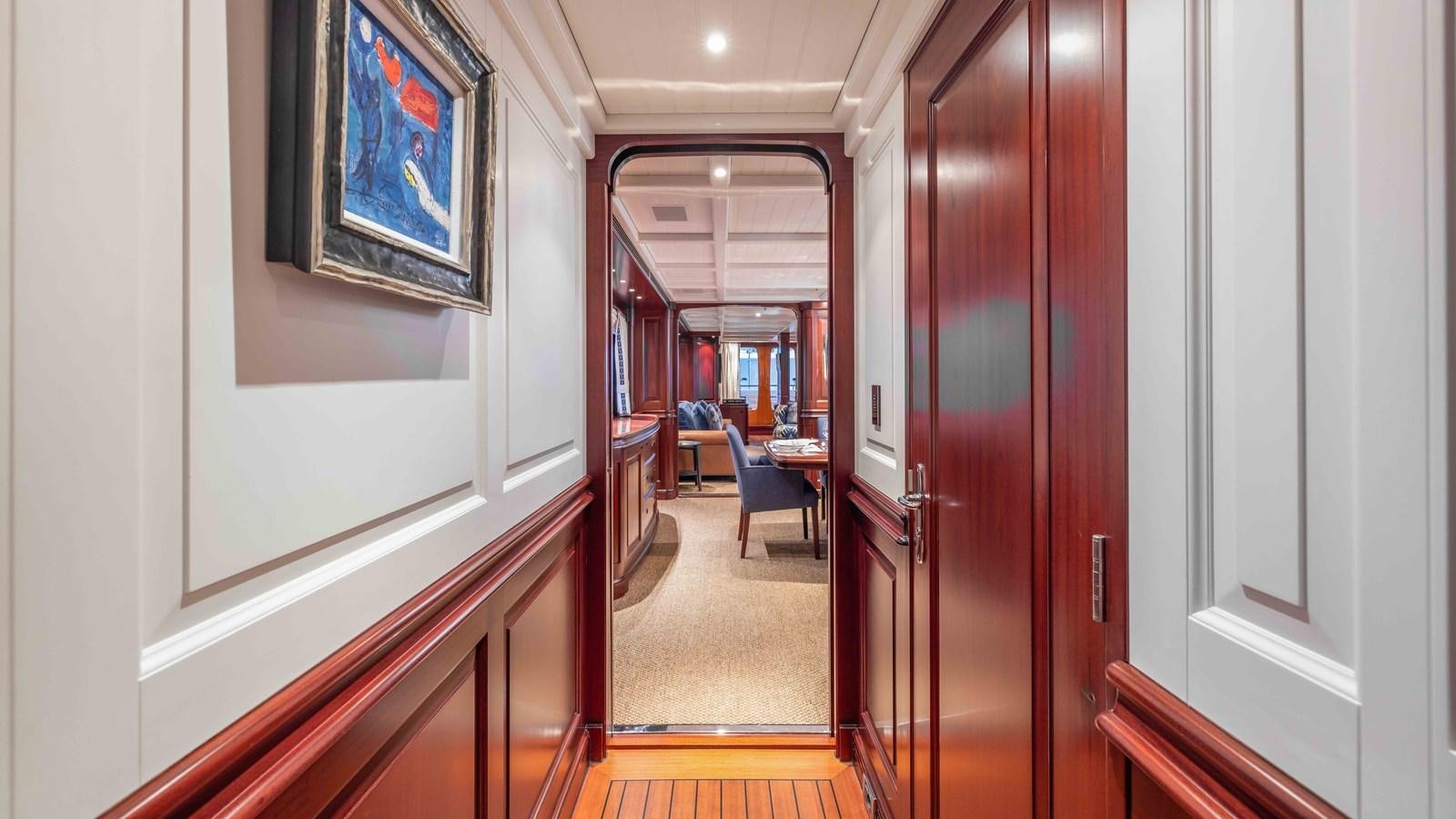 a hallway with a door and a painting on the wall aboard AWATEA Yacht for Sale