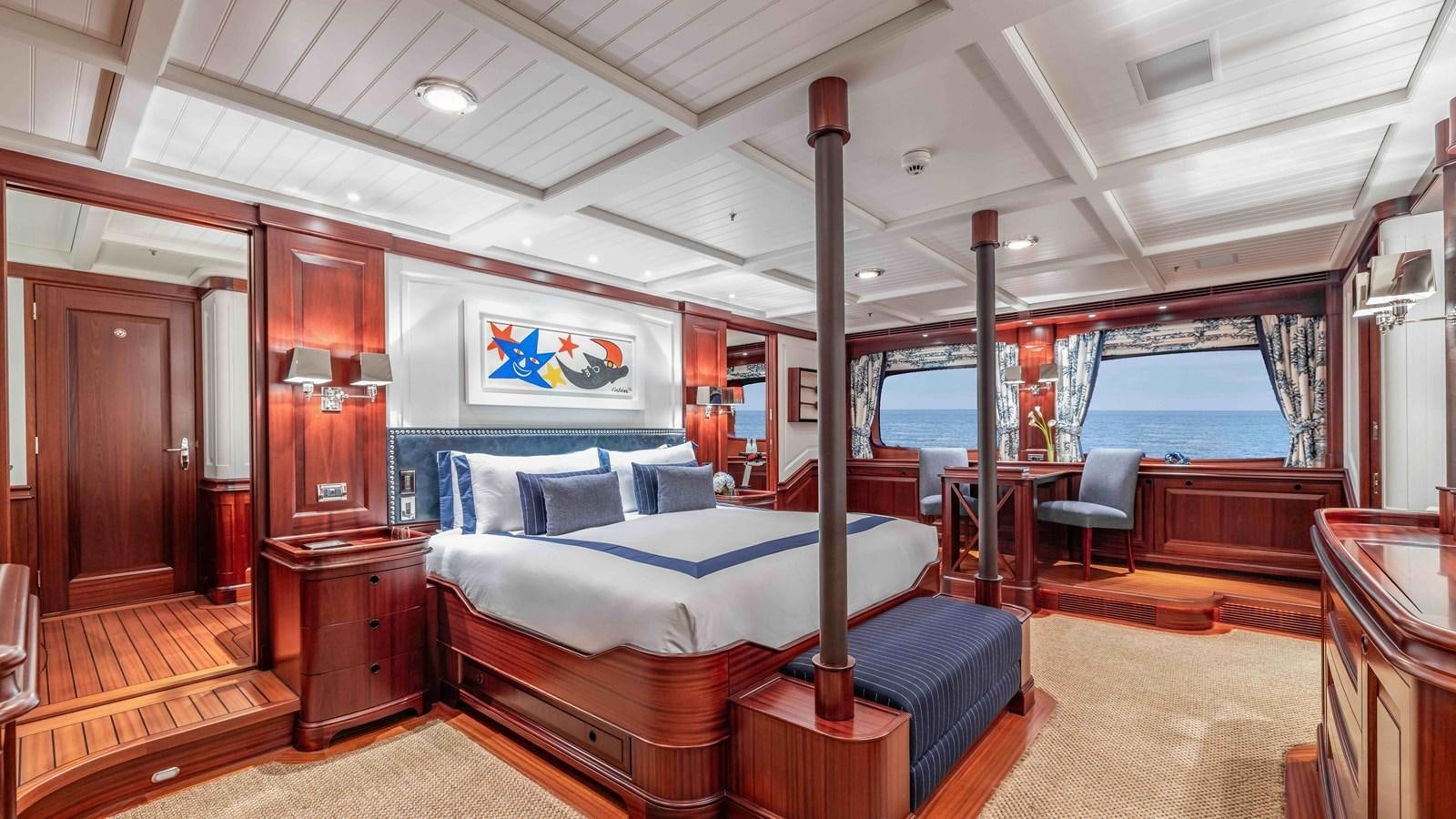 a bedroom with a bed and a chair aboard AWATEA Yacht for Sale