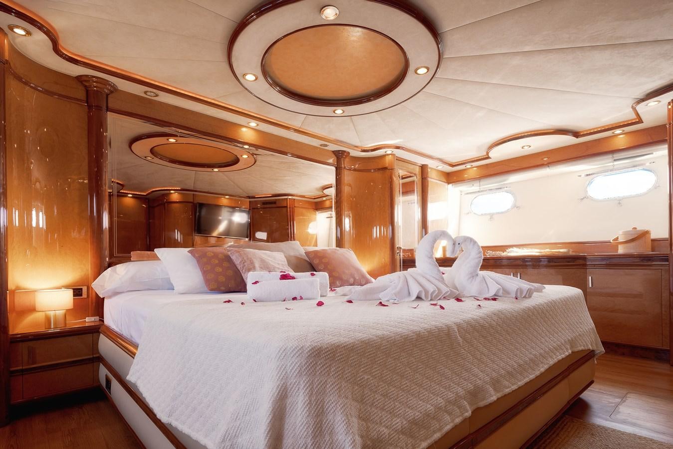 a large bed with a chandelier above it aboard NEPHENTA Yacht for Sale