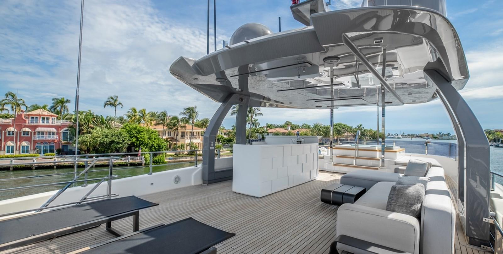 a deck with a large glass structure and a pool with chairs and trees aboard OCEAN Z Yacht for Sale
