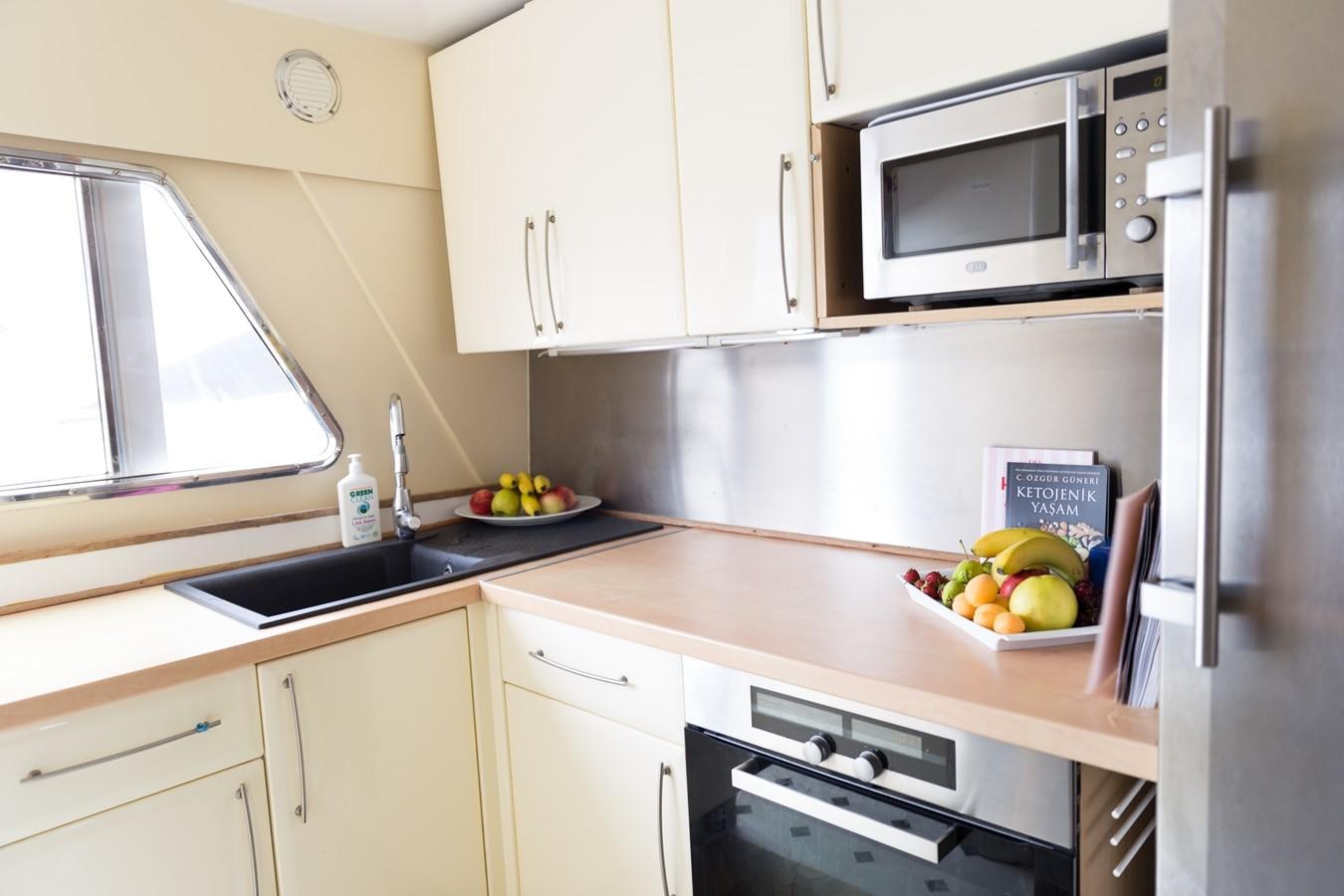 a kitchen with white cabinets aboard ENIGMA BLUE Yacht for Sale
