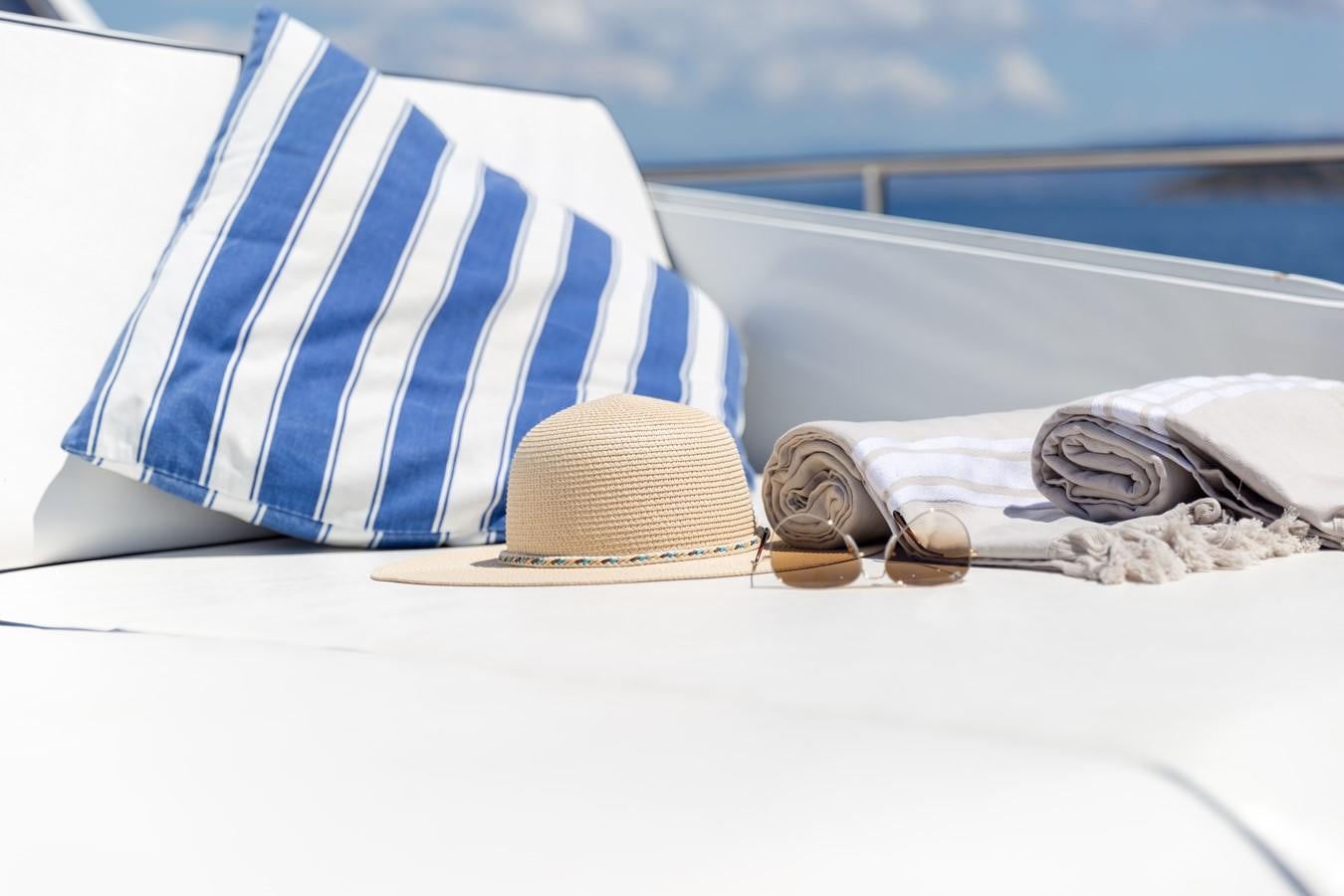 a hat and sunglasses on a beach aboard ENIGMA BLUE Yacht for Sale