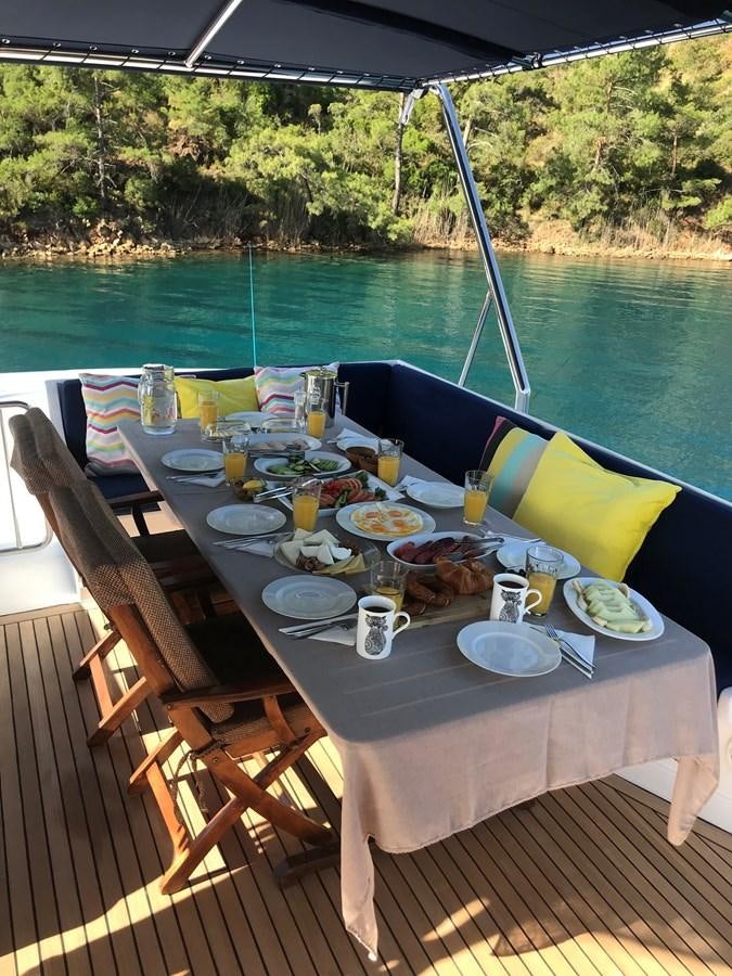 a table set for a meal on a deck aboard ENIGMA BLUE Yacht for Sale