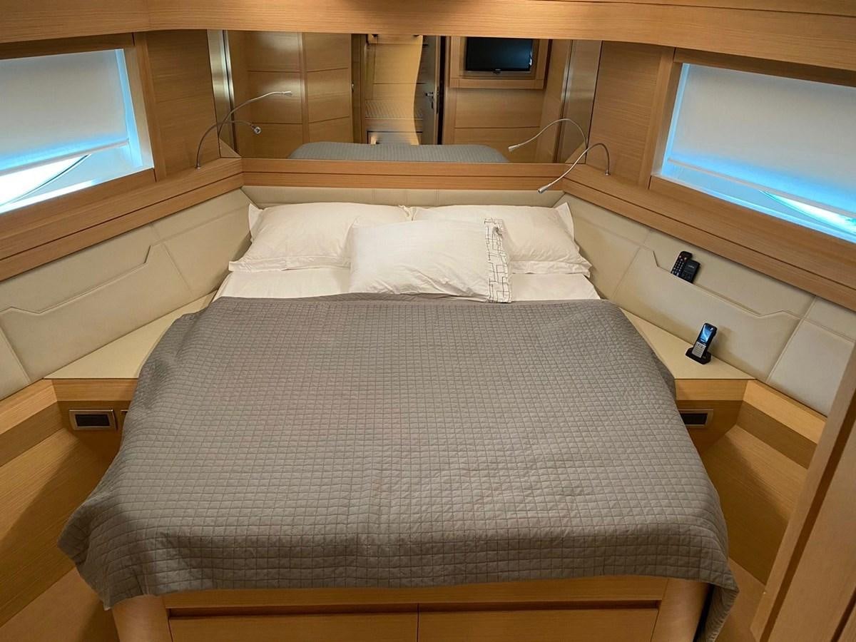 a bed with a television on the wall aboard X-TREM I Yacht for Sale
