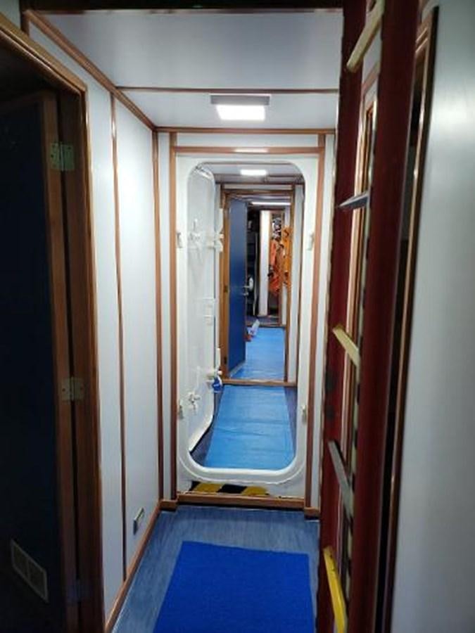 a hallway with a blue carpet aboard 2005 CUSTOM PILOT BOAT Yacht for Sale