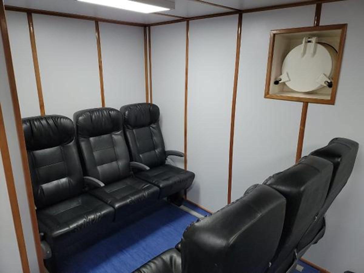 a room with leather chairs aboard 2005 CUSTOM PILOT BOAT Yacht for Sale