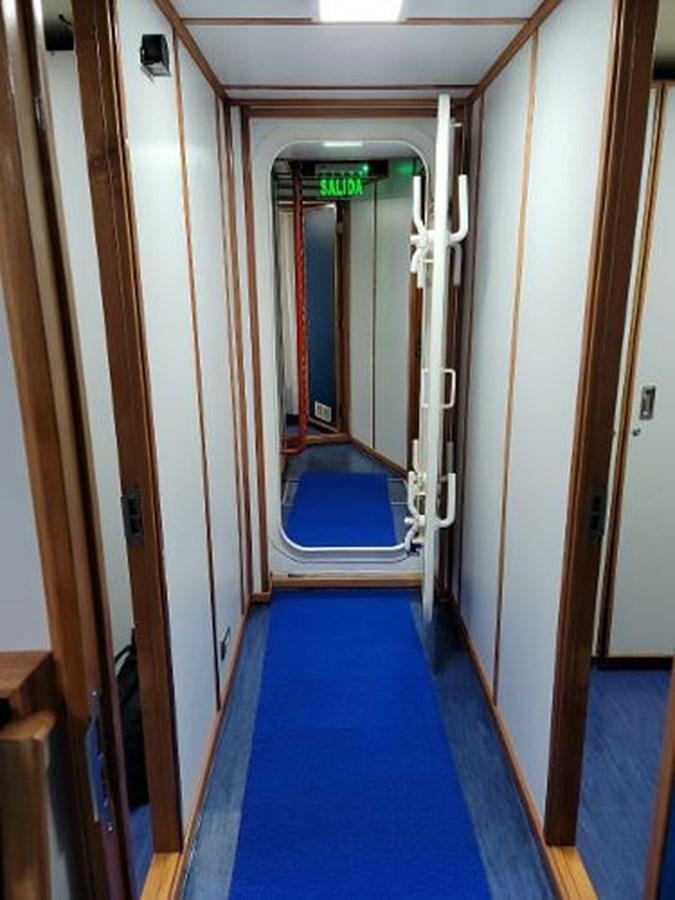 a hallway with blue carpet aboard 2005 CUSTOM PILOT BOAT Yacht for Sale