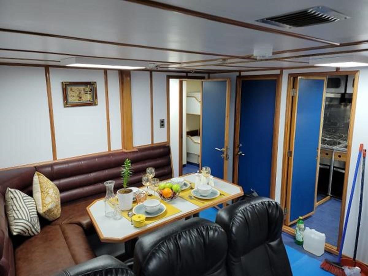 a living room with a couch and a table aboard 2005 CUSTOM PILOT BOAT Yacht for Sale