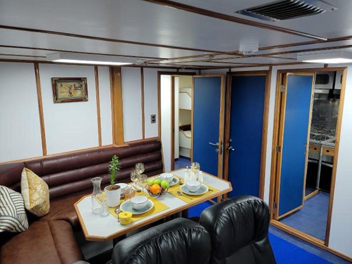 a living room with a couch and a table aboard 2005 CUSTOM PILOT BOAT Yacht for Sale