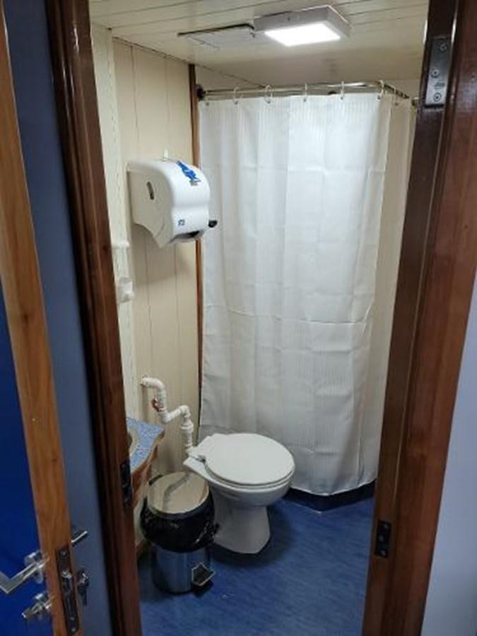 a bathroom with a toilet and a shower curtain aboard 2005 CUSTOM PILOT BOAT Yacht for Sale