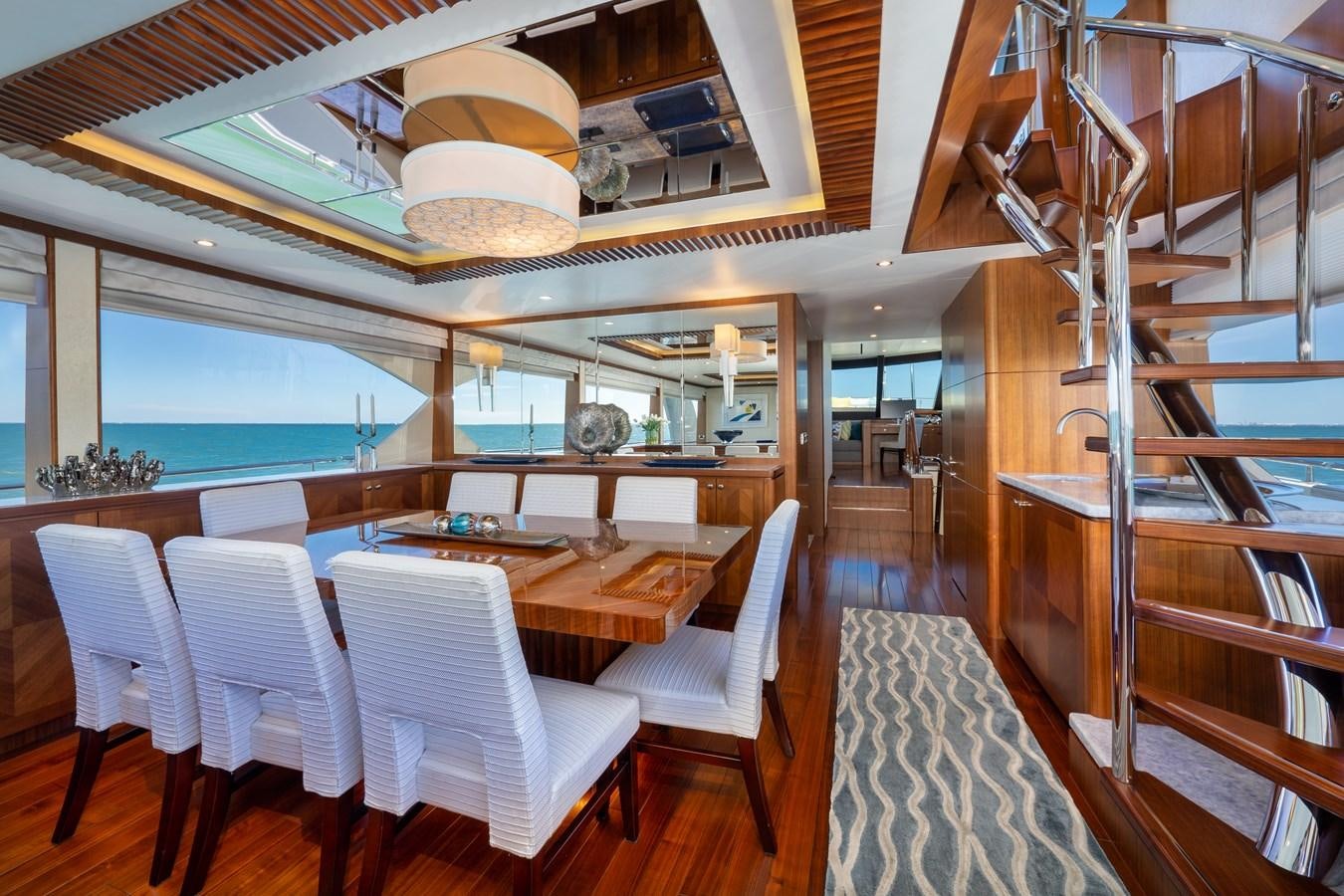 a room with a table chairs and a staircase aboard SEA N SEA Yacht for Charter