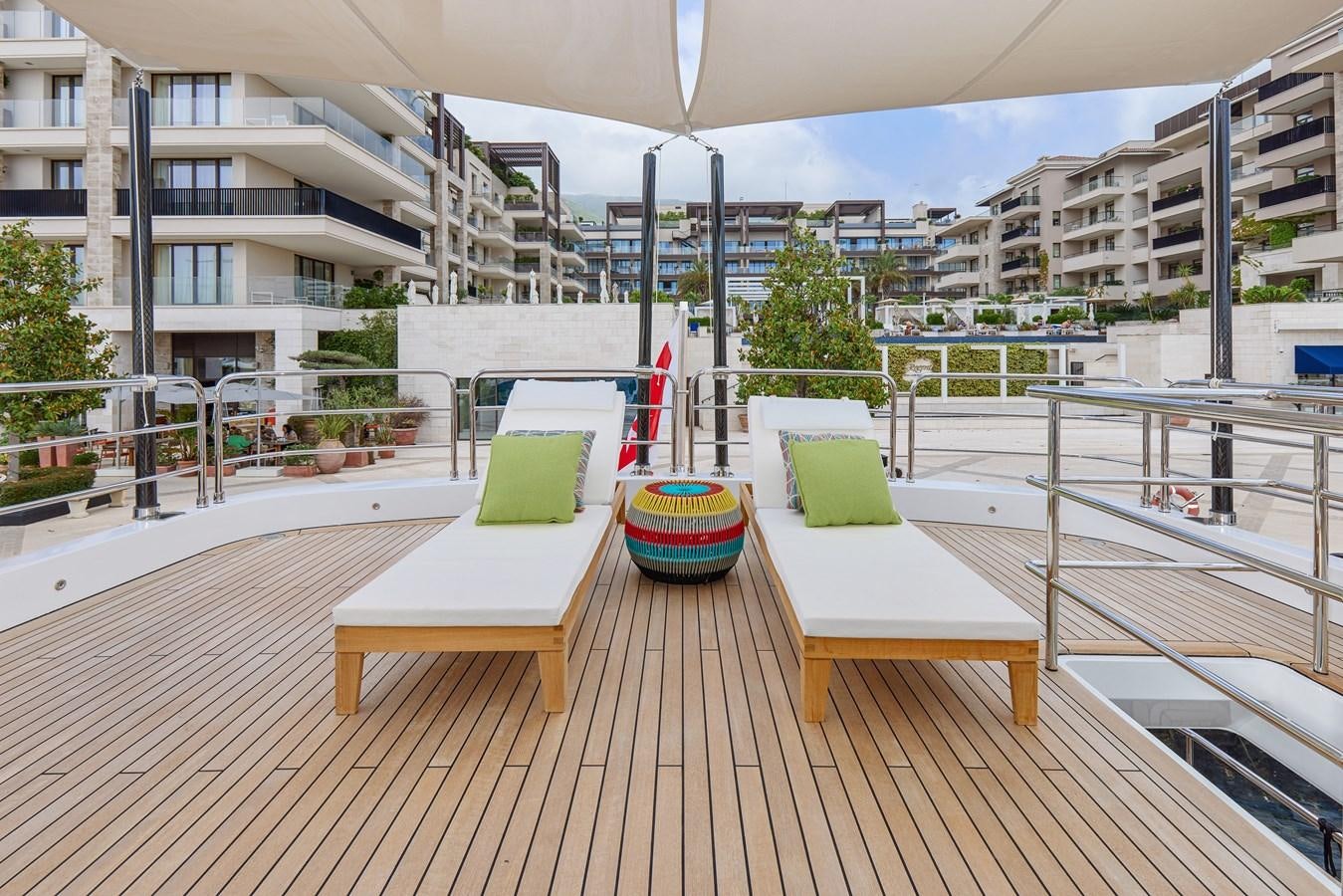 a deck with a table and chairs aboard STEEL TRANSATLANTIC NAVETTA 2022 "TEMBEA" Yacht for Sale