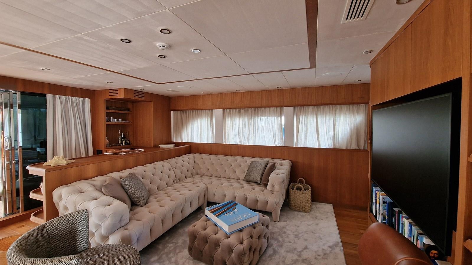 a living room with a couch and a tv aboard STEEL TRANSATLANTIC NAVETTA 2022 "TEMBEA" Yacht for Sale