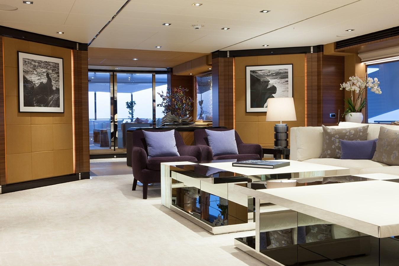 a living room with a large table and couches aboard DAISY D Yacht for Sale