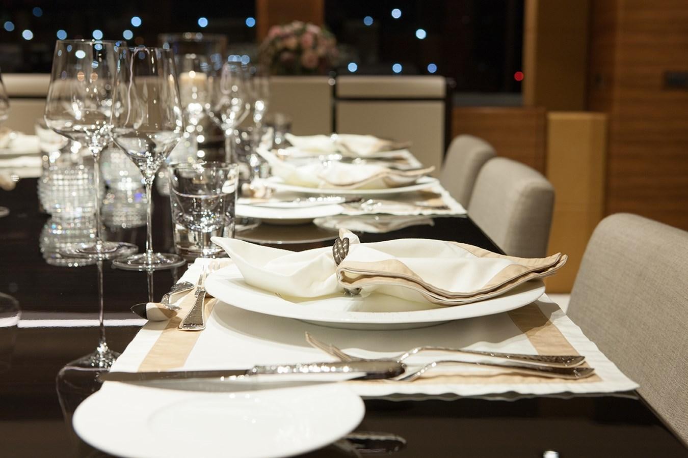 a table with plates and glasses on it aboard DAISY D Yacht for Sale