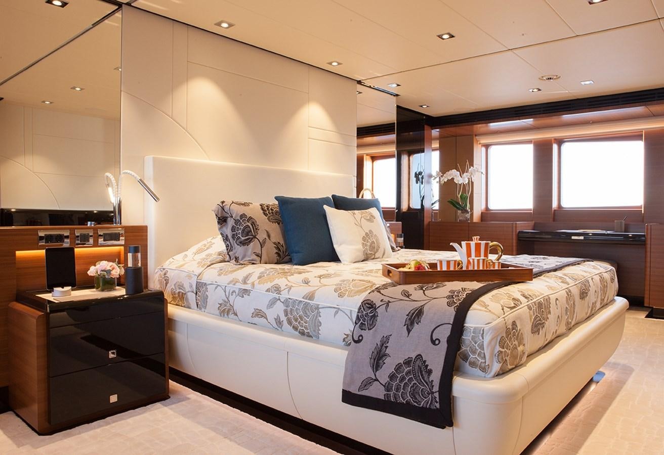 a bedroom with a bed and a table aboard DAISY D Yacht for Sale