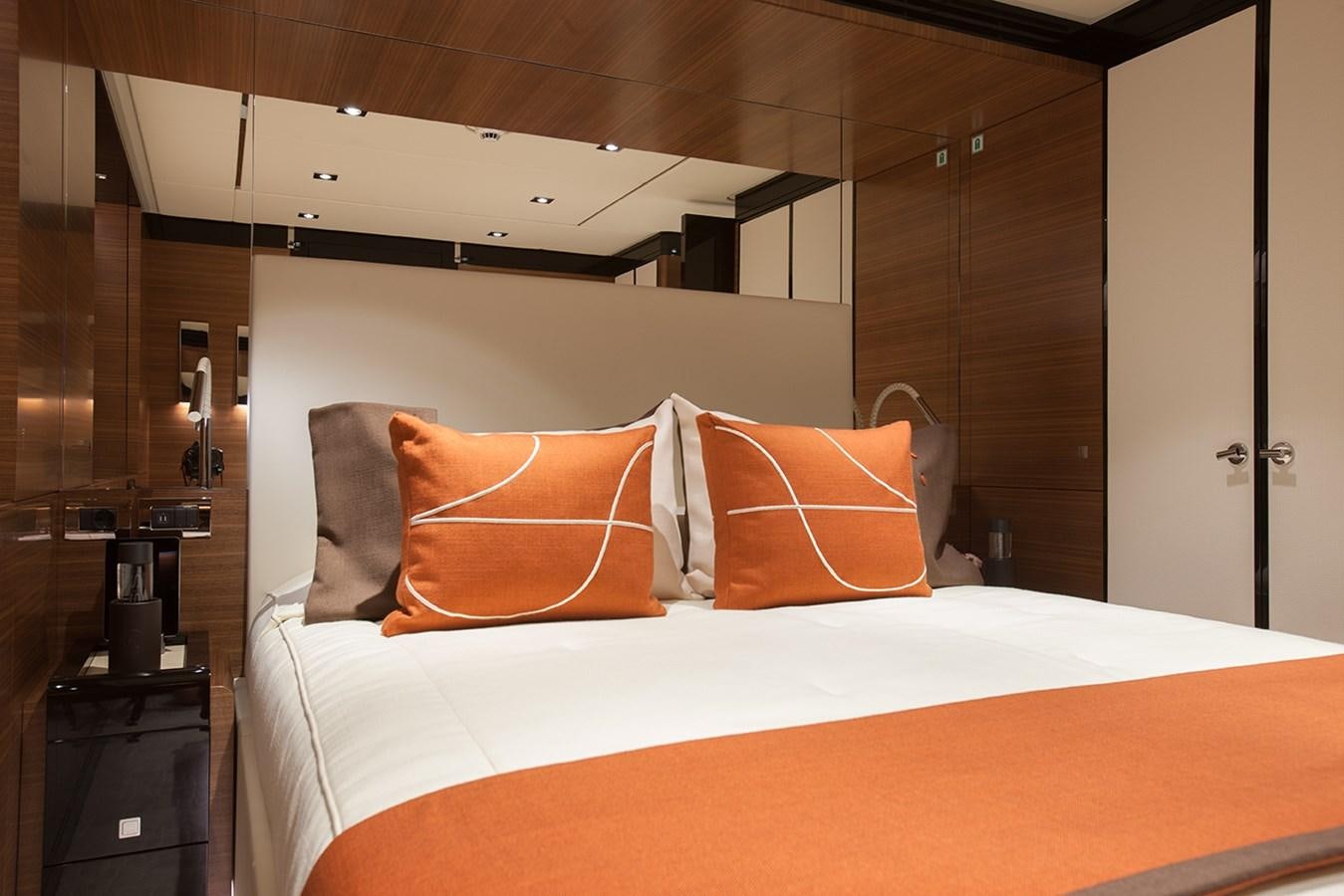 a bed with orange pillows aboard DAISY D Yacht for Sale