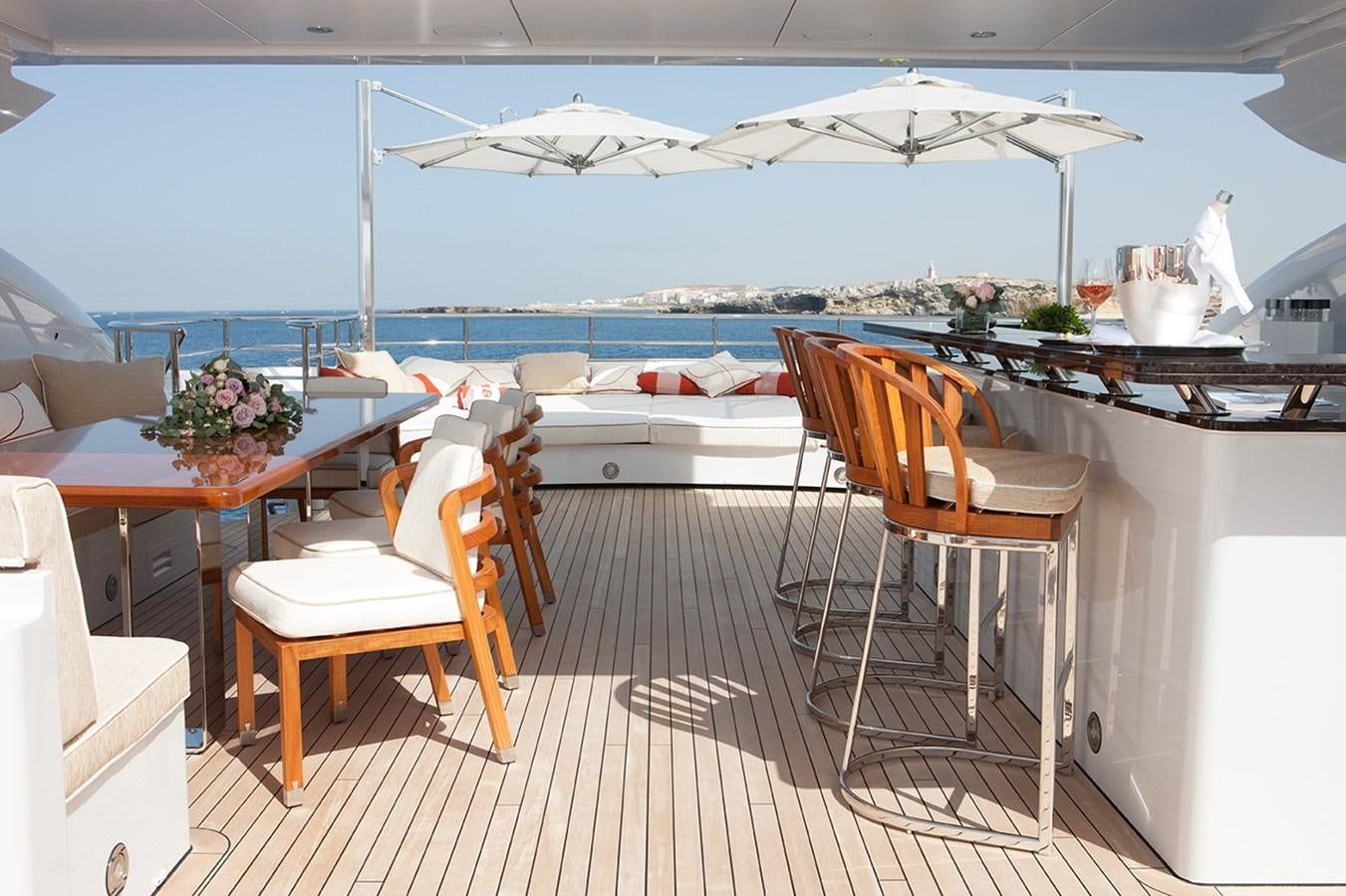 a room with a table chairs and a large body of water aboard DAISY D Yacht for Sale