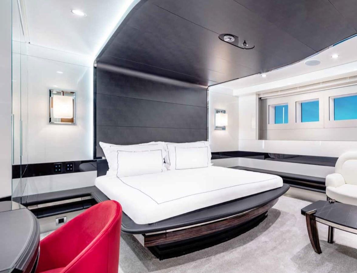 a room with a bed and a chair aboard EUPHORIA II Yacht for Sale