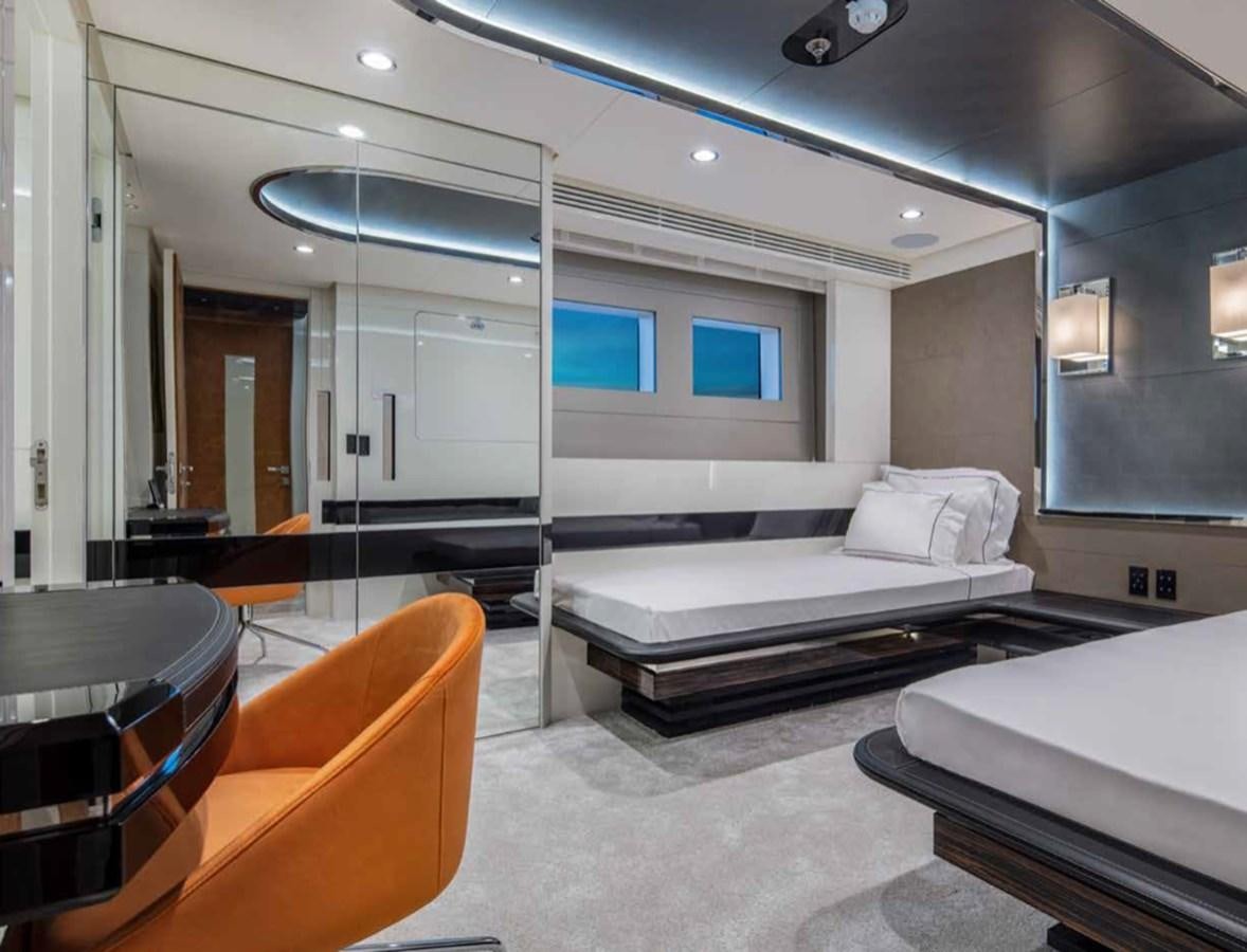 a room with a bed and a desk aboard EUPHORIA II Yacht for Sale