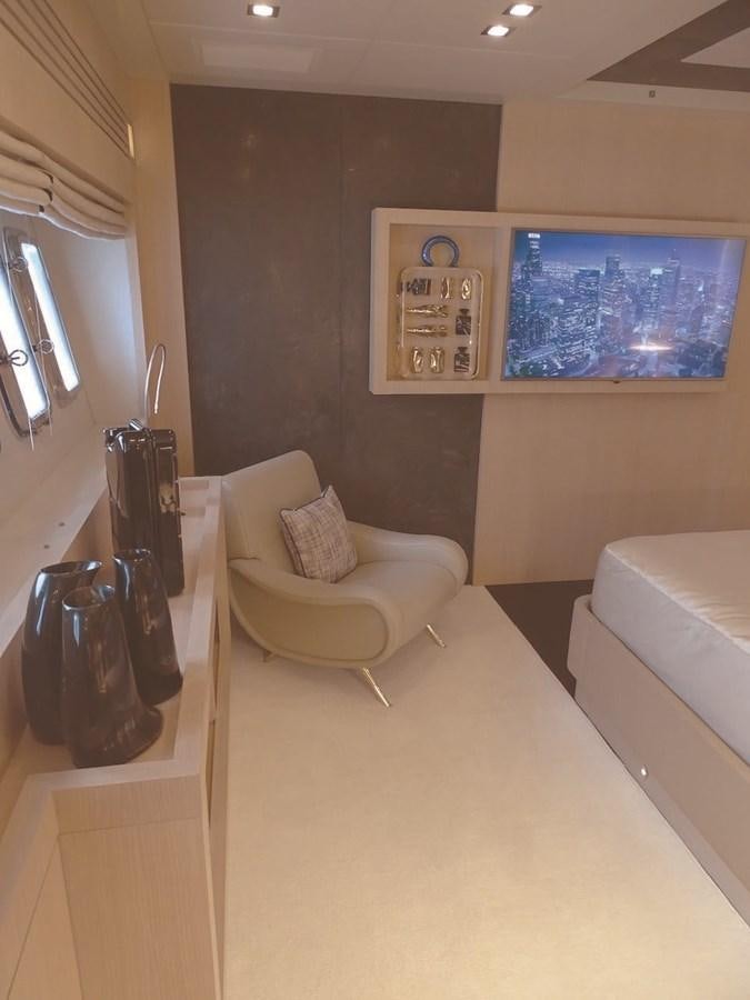 a room with a couch and a television on the wall aboard TOTAL Yacht for Charter