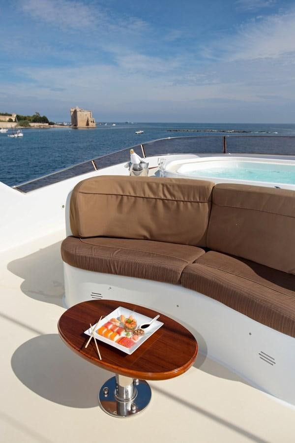 a coffee table on a balcony overlooking a body of water aboard INOUIS Yacht for Sale
