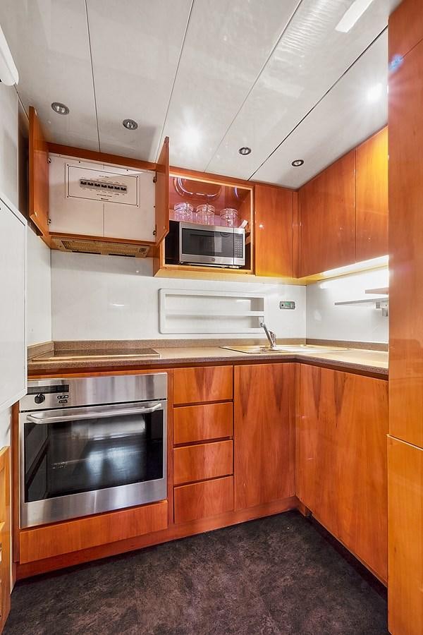 a kitchen with wooden cabinets aboard HAKUNA MATATA Yacht for Sale