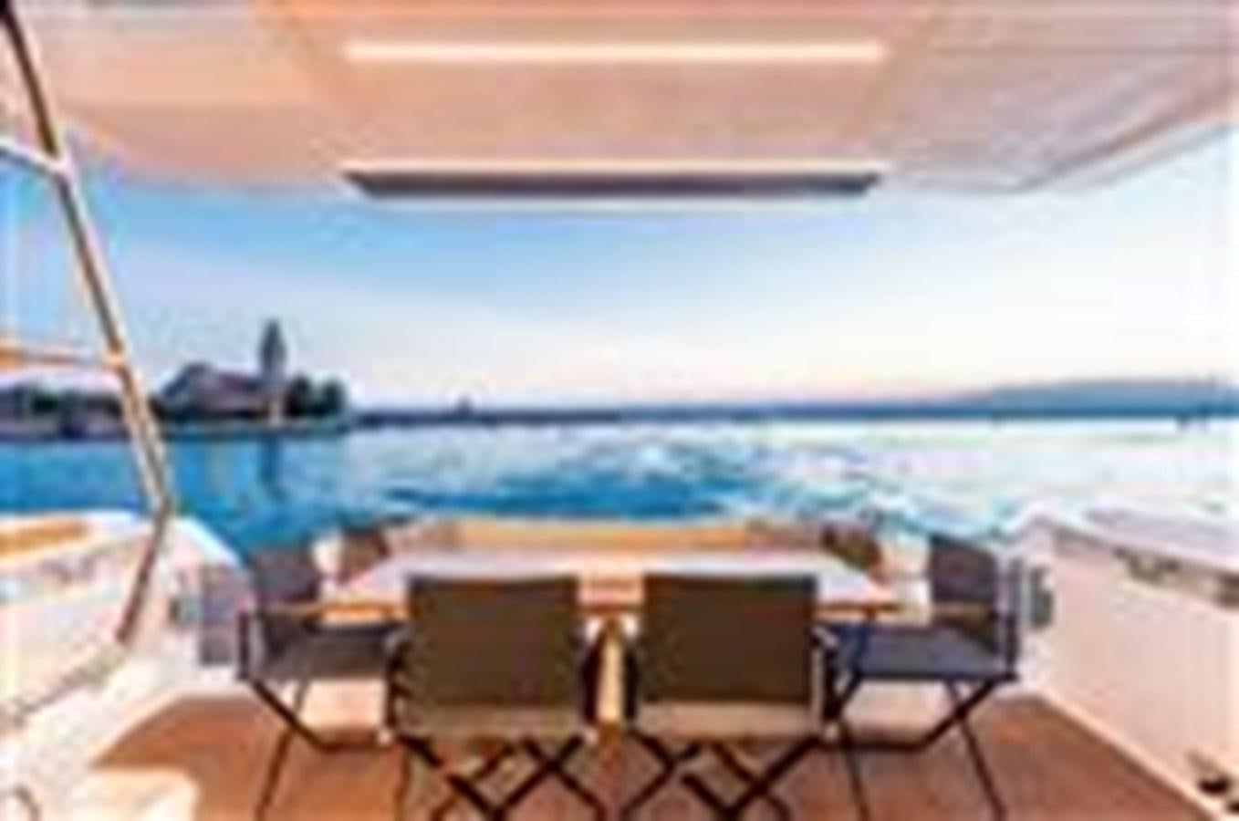 a table and chairs on a balcony aboard FERRETTI YACHTS 670  Yacht for Sale