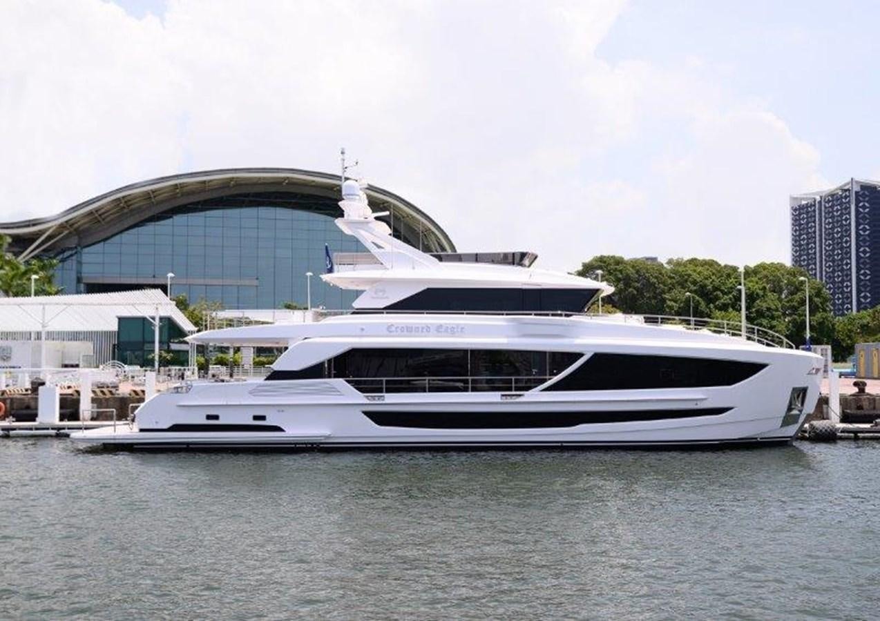 a white yacht in a harbor aboard CROWNED EAGLE Yacht for Sale