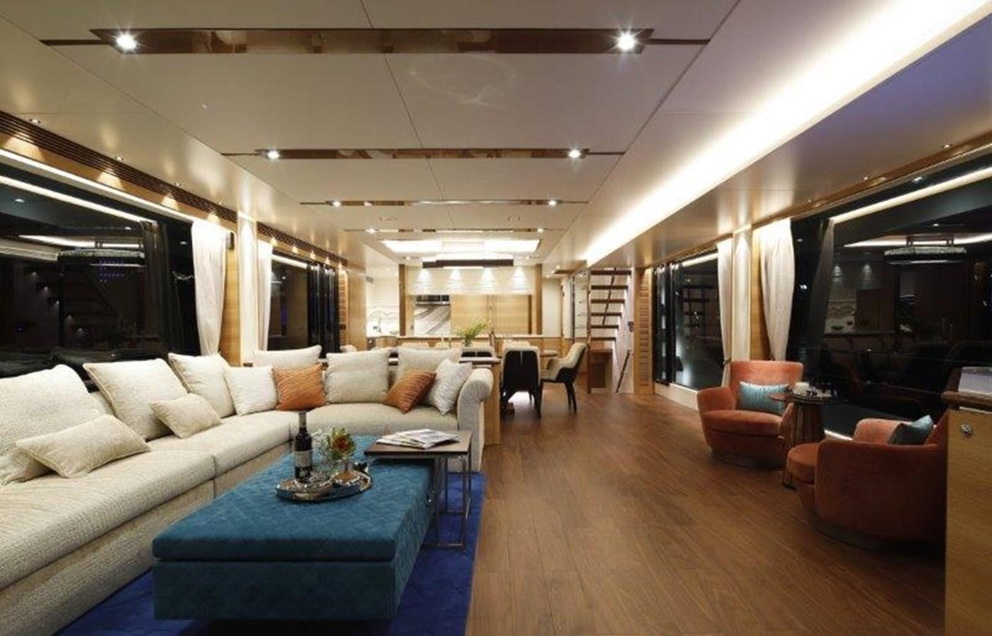 a living room with a large blue table and chairs aboard CROWNED EAGLE Yacht for Sale